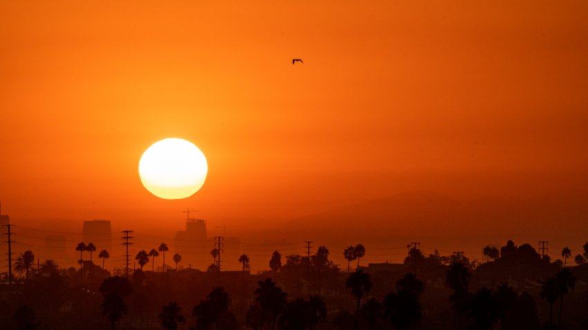 A hot summer sun rises over Los Angeles.