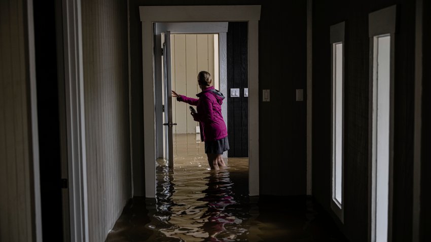 Carole Smith walks through her flooded home